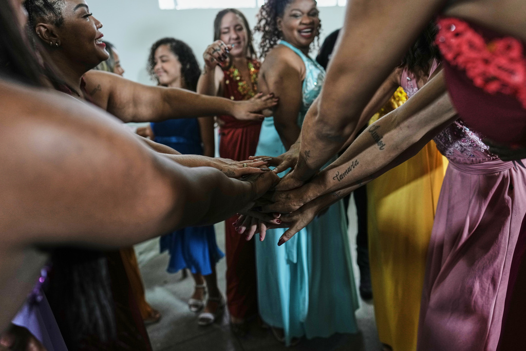 Inmates wish each other good luck before competing in the Voice of Freedom rehabilitation program singing contest at the Djanira Dolores de Oliveira women's penitentiary in Rio de Janeiro, Friday, Jan. 23, 2026. (AP Photo/Silvia Izquierdo)