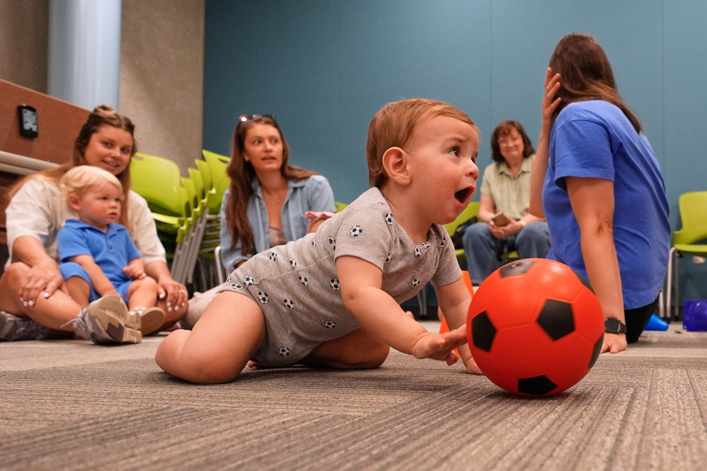 Ten-month-old Beck Ehinger plays with a soccer ball at a program introducing toddlers to the sport ahead of the World Cup soccer tournament Thursday, June 4, 2026, in Lenexa, Kan. (AP Photo/Charlie Riedel)