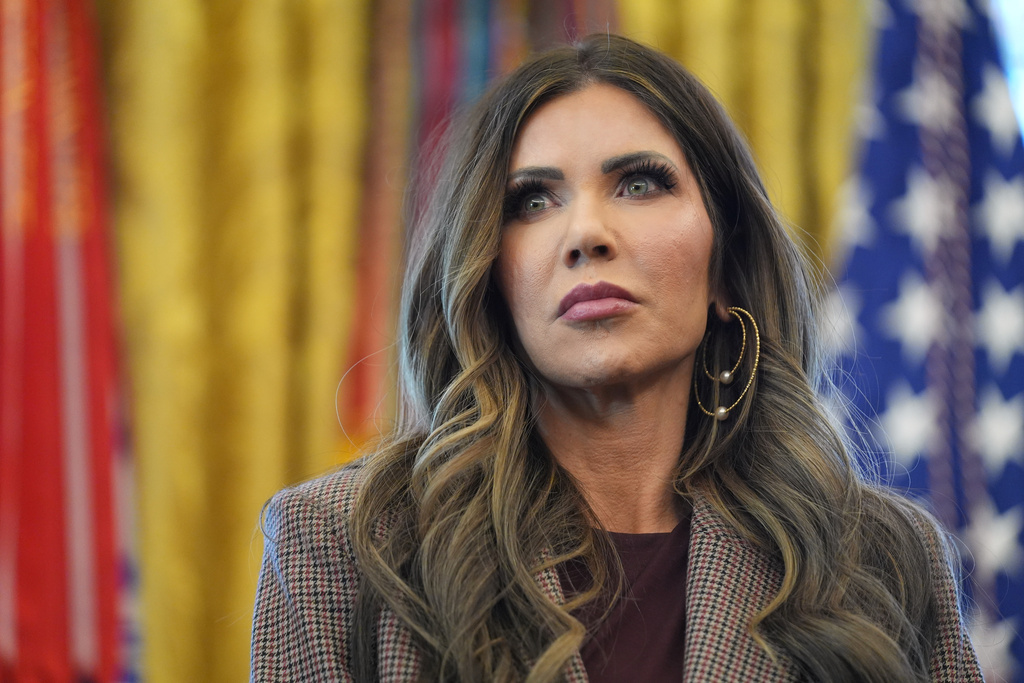 Homeland Security Secretary Kristi Noem listens as President Donald Trump answers questions from reporters during a meeting with the White House task force on the 2026 FIFA World Cup in the Oval Office of the White House, Monday, Nov. 17, 2025, in Washington. (AP Photo/Evan Vucci)