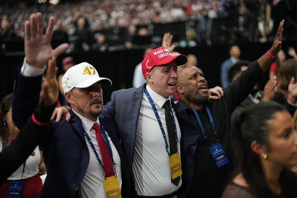 People are overcome with emotion while watching a Charlie Kirk tribute video during a memorial for the conservative activist Sunday, Sept. 21, 2025, at State Farm Stadium in Glendale, Ariz. (AP Photo/John Locher)
