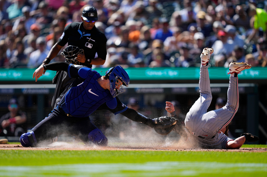 Minnesota Twins' Luke Keaschall, right, scores ahead of the tag of Detroit Tigers catcher Dillon Dingler, left, during the first inning of a baseball game Monday, Sept. 7, 2026, in Detroit. (AP Photo/Paul Sancya)