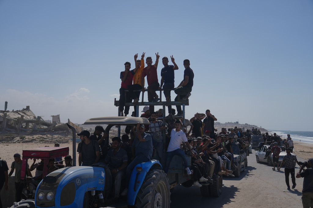 Displaced Palestinians ride on tractors and vehicles loaded with people and belongings along the coastal road near Wadi Gaza in the central Gaza Strip, moving toward Gaza City, Friday, Oct. 10, 2025, after Israel and Hamas agreed to a pause in their war and the release of the remaining hostages. (AP Photo/Abdel Kareem Hana)