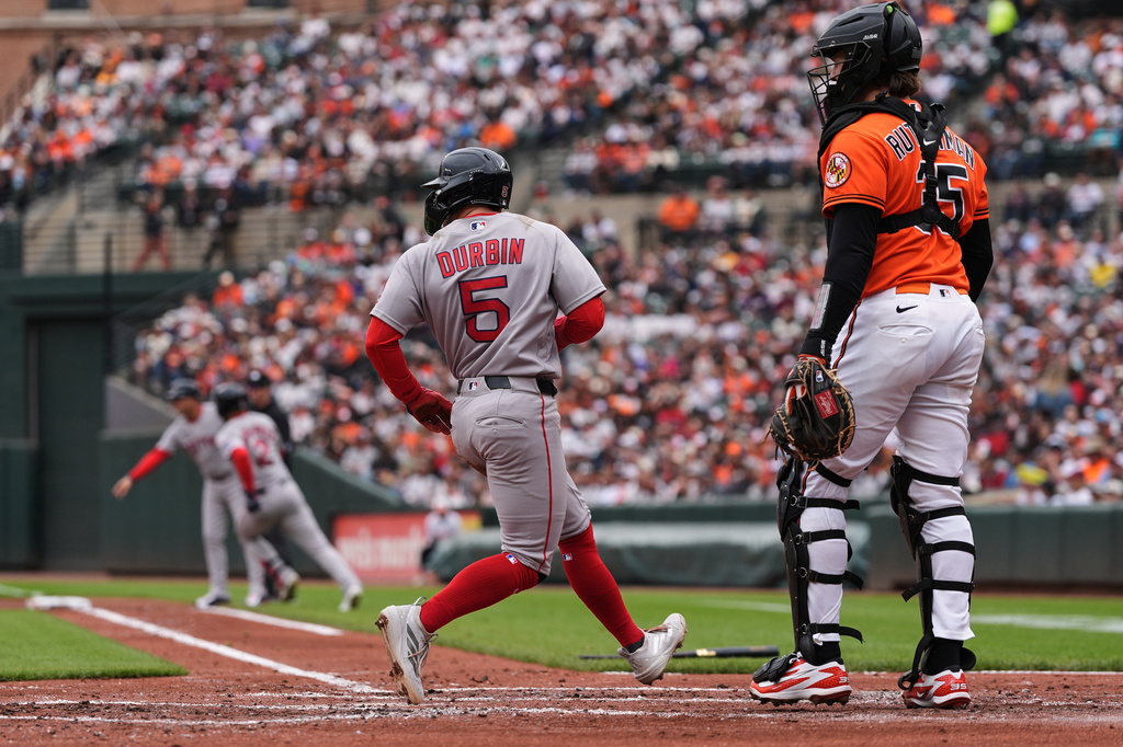 Boston Red Sox' Caleb Durbin (5) scores in front of Baltimore Orioles catcher Adley Rutschman (35) on a hit by Isiah Kiner-Falefa (2) during the second inning of a baseball game, Saturday, April 25, 2026, in Baltimore. (AP Photo/Stephanie Scarbrough)