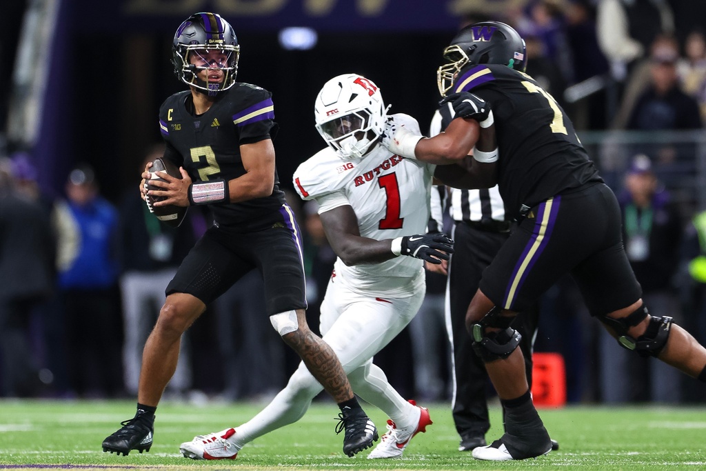 Washington quarterback Demond Williams Jr. (2) looks for an open receiver during an NCAA college football game against Rutgers on Friday, Oct. 10, 2025, in Seattle. (Nick Wagner/The Seattle Times via AP)