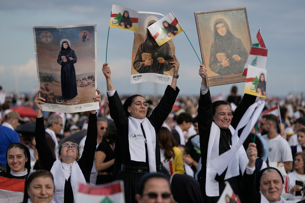 FILE - Nuns hold up images of Lebanese Maronite nun Saint Rafqa as they wait for Pope Leo XIV to celebrate a Holy Mass at Beirut waterfront, in Beirut, Lebanon, Dec. 2, 2025. (AP Photo/Bilal Hussein, File)