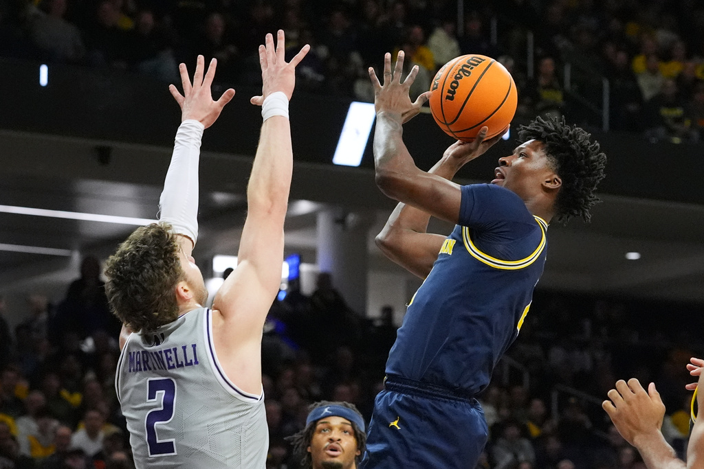 Michigan guard L.j.c.ason, right, drives to the basket against Northwestern forward Nick Martinelli during the first half of an NCAA college basketball game in Evanston, Ill., Wednesday, Feb. 11, 2026. (AP Photo/Nam Y. Huh)