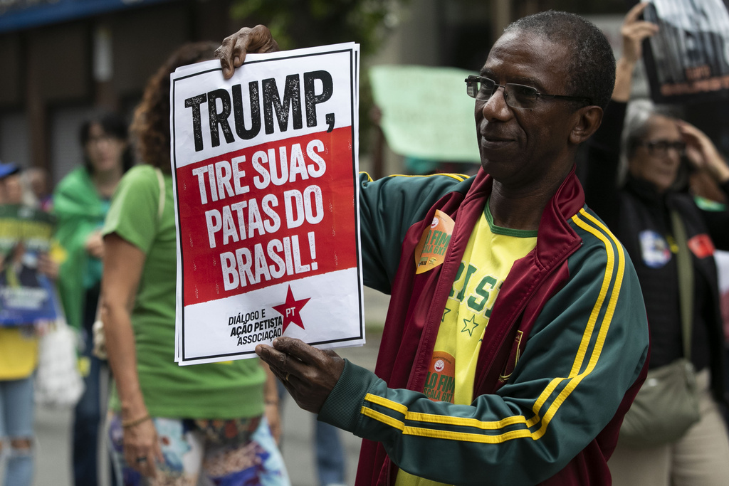 A demonstrator holds a sign that reads in Portuguese, "Trump get your paws off Brazil!" during a march against economic inequality, on Independence Day in Rio de Janeiro, Sunday, Sept. 7, 2025. (AP Photo/Bruna Prado)