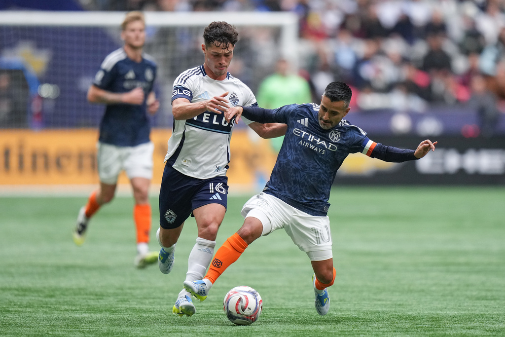 Vancouver Whitecaps' Sebastian Berhalter (16) and New York City FC's Maximiliano Moralez, right, vie for the ball during the first half of an MLS soccer match in Vancouver, British Columbia, Saturday, April 11, 2026. (Darryl Dyck/The Canadian Press via AP)