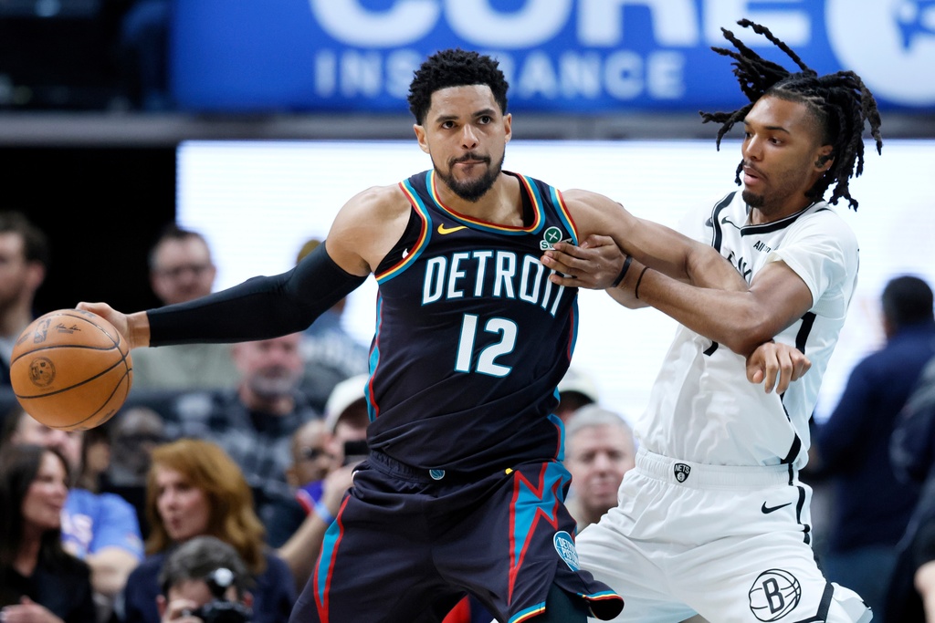 Detroit Pistons forward Tobias Harris (12) drives against Brooklyn Nets forward Ziaire Williams, right, during the first half of an NBA basketball game Saturday, March 7, 2026, in Detroit. (AP Photo/Duane Burleson)