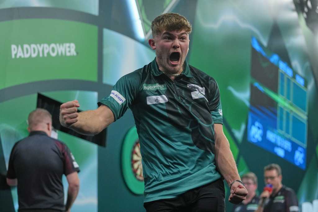 Charlie Manby of England celebrates as he takes part in a round one match at the World Darts Championships, at Alexandra Palace in London, Monday, Dec. 15, 2025. (AP Photo/Kin Cheung)