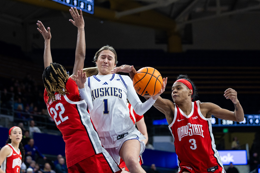 Washington guard Hannah Stines (1) drives through Ohio State guard Jaloni Cambridge (22) and guard Kennedy Cambridge (3) during the first quarter of an NCAA college basketball game, Thursday, Feb. 5, 2026, in Seattle. (AP Photo/Maddy Grassy)