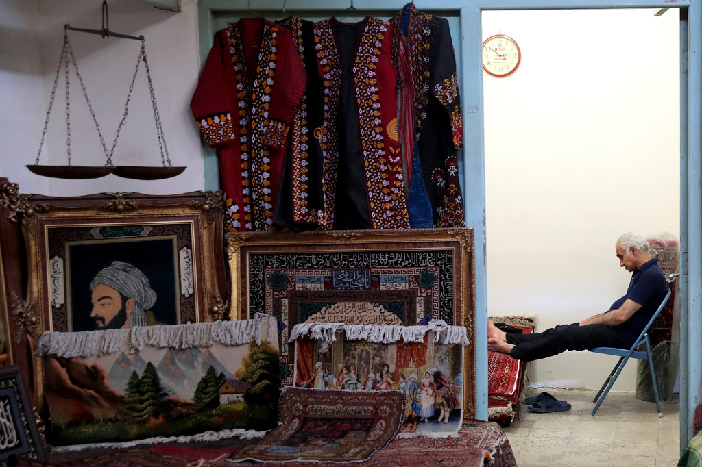 FILE -A carpet seller sits at his shop in the old main bazaar in Tehran, Iran, June 23, 2019. (AP Photo/Ebrahim Noroozi, File)