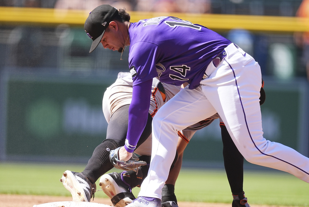 Colorado Rockies shortstop Ezequiel Tovar, front, tags out San Francisco Giants' Heliot Ramos, back, at second base as Ramos tried to stretch a single into a double in the third inning of a baseball game Monday, Sept. 1, 2025, in Denver. (AP Photo/David Zalubowski)