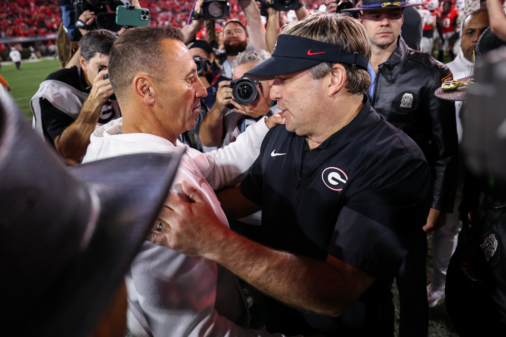 Texas head coach Steve Sarkisian, left, meets at midfield with Georgia head coach Kirby Smart, right, after an NCAA college football game, Saturday, Nov. 15, 2025, in Athens, Ga. (AP Photo/Colin Hubbard)