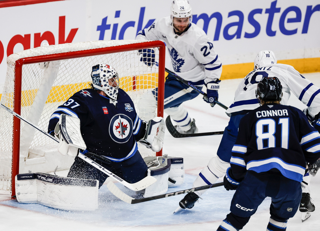 Winnipeg Jets goaltender Connor Hellebuyck (37) saves a shot by Toronto Maple Leafs' Steven Lorentz (18) during second-period NHL hockey game action in Winnipeg, Manitoba, Saturday, Jan. 17, 2026. (John Woods/The Canadian Press via AP)