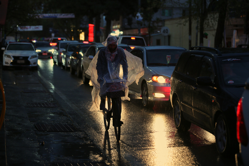 A man rides a bicycle through heavy rain in Kabul, Afghanistan, Tuesday, March 31, 2026. (AP Photo/Siddiqullah Alizai)