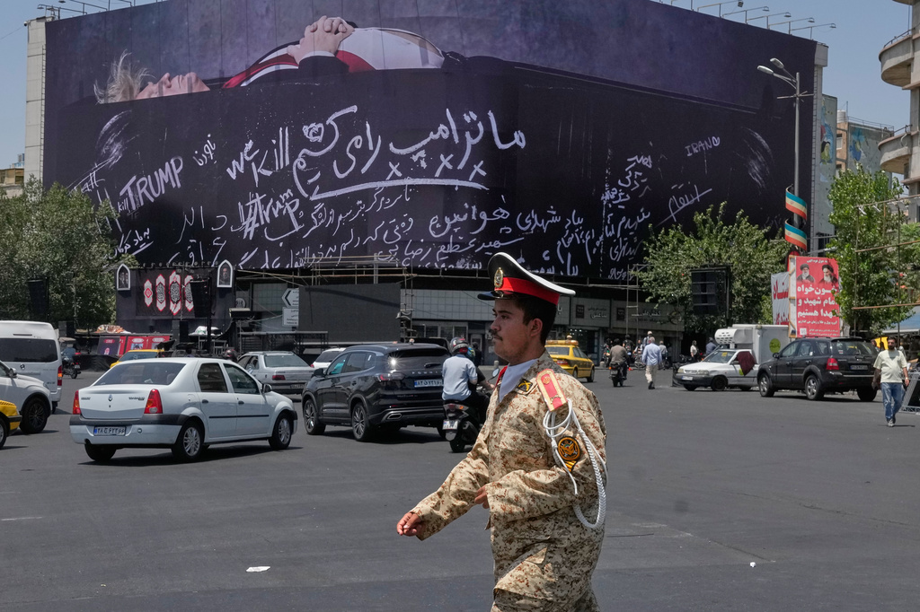An army cadet walks past a billboard bearing anti-Trump messages, including the phrase "We Kill Trump," at Islamic Revolution Square in downtown Tehran, Iran, Wednesday, July 15, 2026. (AP Photo/Vahid Salemi)