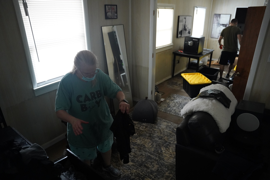 Deborah Daily and her son, Michael Daily, clean up a flooded home in Indianapolis, Monday, Aug. 17, 2026. (AP Photo/Obed Lamy)