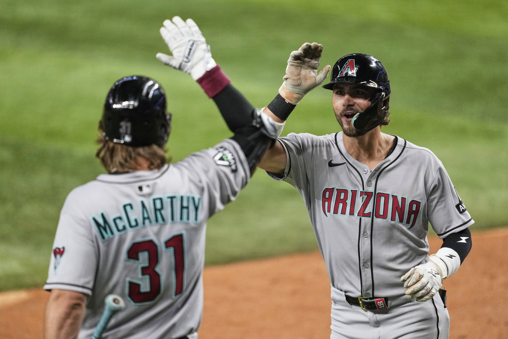 Arizona Diamondbacks' Blaze Alexander, right, and Jake McCarthy (31) celebrate after Alexander hit a solo home run in the sixth inning of a baseball game against the Texas Rangers Monday, Aug. 11, 2025, in Arlington, Texas. (AP Photo/Tony Gutierrez)
