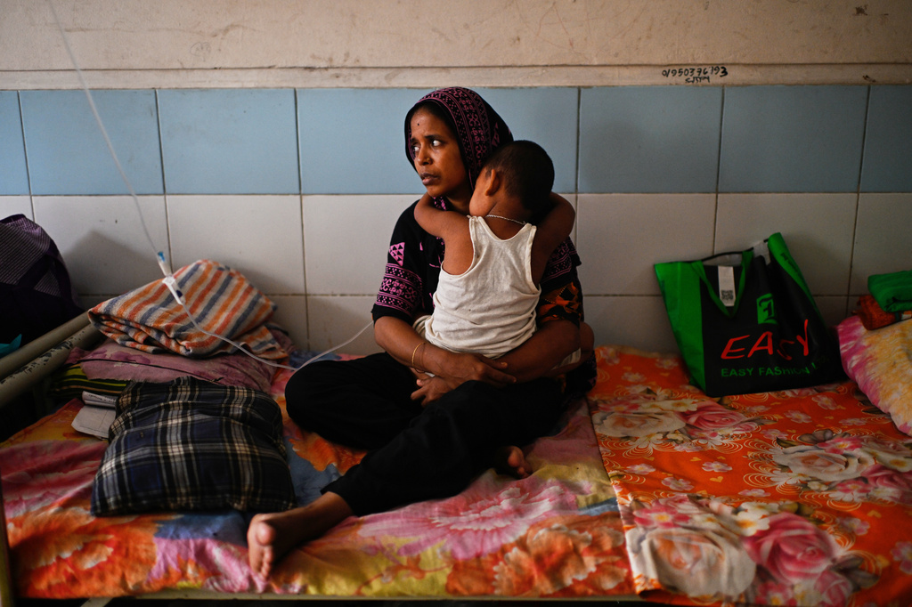 A woman takes care of her child while getting treatment for measles during the outbreak, in a hospital in Dhaka, Bangladesh, Tuesday, Sept. 8, 2026. (AP Photo/Mahmud Hossain Opu)