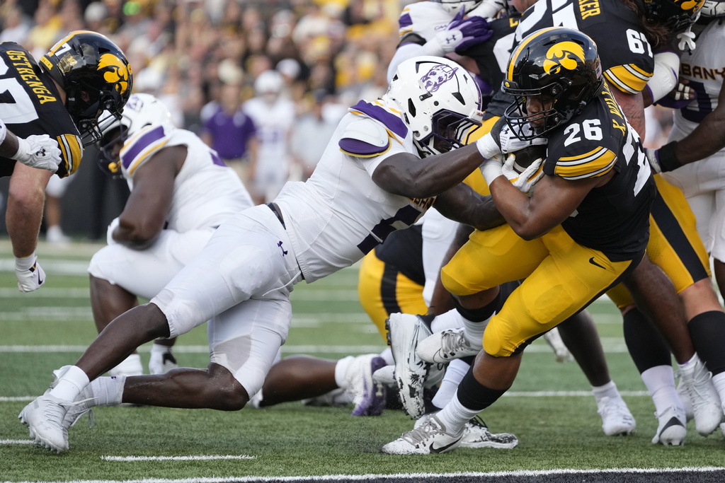 Iowa running back Xavier Williams (26) scores a touchdown ahead of Albany linebacker Ron Holmes (5) during the first half of an NCAA college football game, Saturday, Aug. 30, 2025, in Iowa City, Iowa. (Photo by Charlie Neibergall)