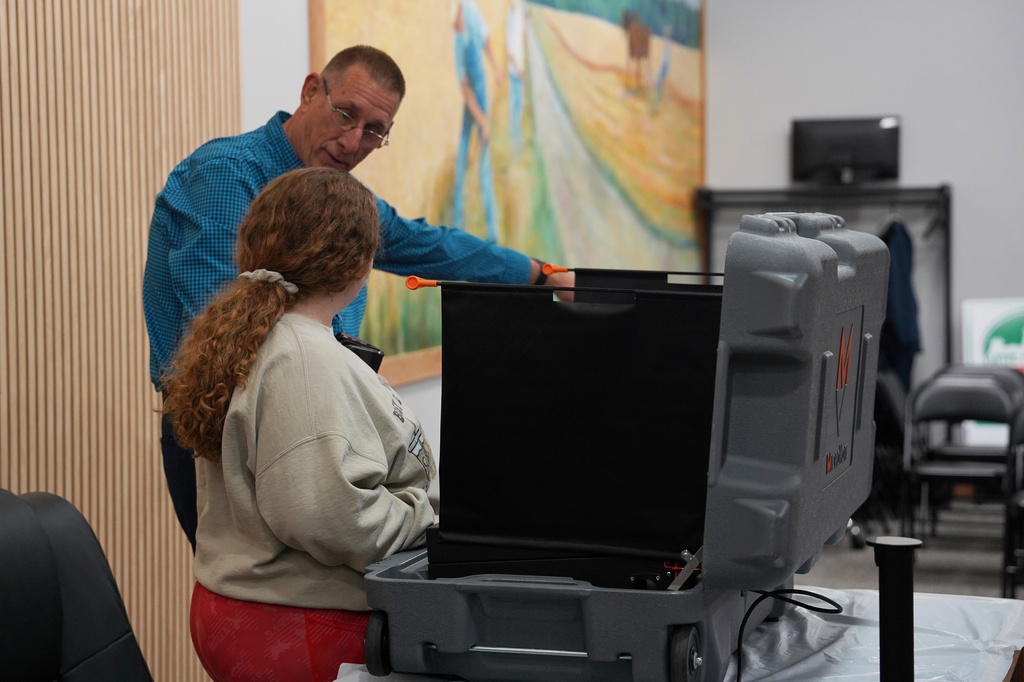 A poll worker talks with a voter at a polling booth in in Columbus, Ind., on Thursday, May 5, 2026. (AP Photo/Obed Lamy)