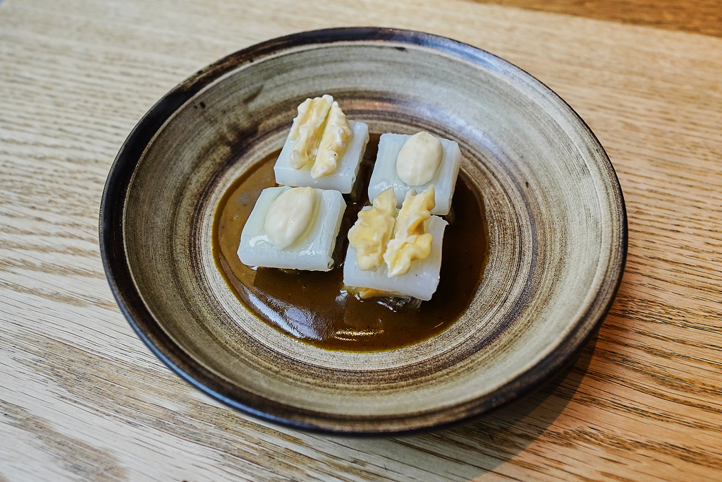 A cured squid, white cabbage, hazelnuts and walnuts dish served at restaurant Kadeau in Copenhagen, Denmark, Feb. 12, 2026. (AP Photo/James Brooks)
