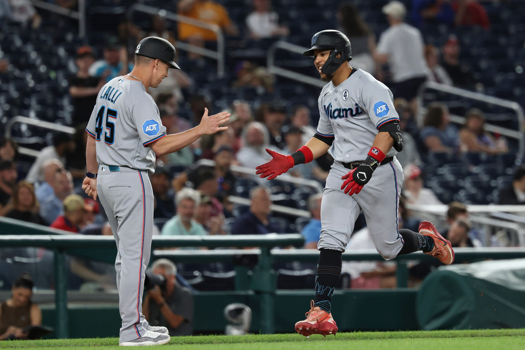 Miami Marlins' Heriberto Hernández, right, is greeted by third base coach Blake Lalli (45) as he runs the bases after hitting two-run home run off Washington Nationals pitcher Mitchell Parker which also scored Jakob Marsee during the ninth inning of a baseball game, Tuesday, June 2, 2026, in Washington. (AP Photo/Terrance Williams)