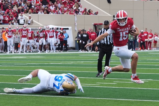 Indiana quarterback Fernando Mendoza (15) runs past UCLA defensive lineman Jacob Busic (97) during the first half of an NCAA college football game, Saturday, Oct. 25, 2025, in Bloomington, Ind. (AP Photo/Darron Cummings) Indiana quarterback Fernando Mendoza (15) runs past UCLA defensive lineman Jacob Busic (97) during the first half of an NCAA college football game, Saturday, Oct. 25, 2025, in Bloomington, Ind. (AP Photo/Darron Cummings)