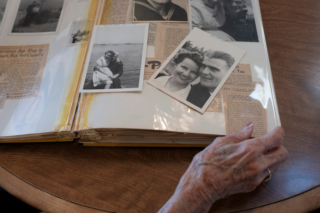 Alice Darrow looks at pictures of her and her late husband, Dean Darrow, taken in July 1942, Thursday, Oct. 23, 2025, at her home in Danville, Calif. (AP Photo/Laure Andrillon)