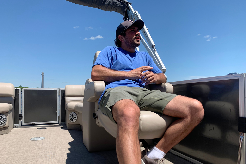 Malik Amine sits on his family's boat Thursday, May 28, 2026, in Dexter Township, Mich. (AP Photo/Mike Householder)