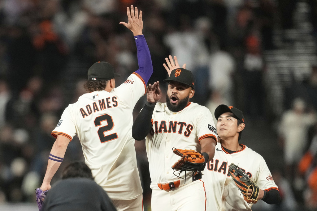 San Francisco Giants' Willy Adames (2) celebrates with Heliot Ramos, middle, and Jung Hoo Lee after a baseball game against the Arizona Diamondbacks in San Francisco, Monday, Sept. 8, 2025. (AP Photo/Jeff Chiu)