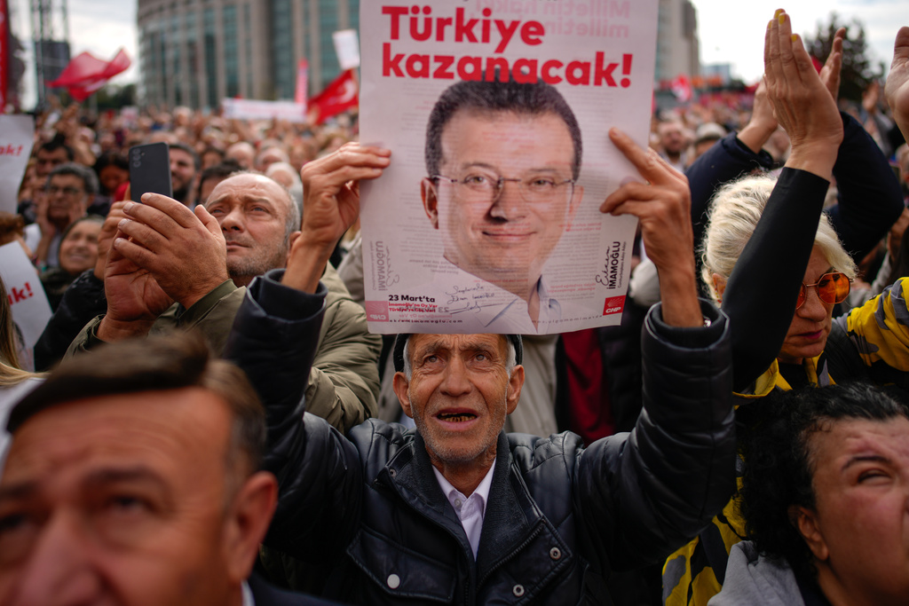 People shout slogans during a rally in support of Istanbul's imprisoned opposition Mayor Ekrem Imamoglu as he appears for a hearing, at the Caglayan courthouse, in Istanbul, Turkey, Sunday, Oct. 26, 2025. The poster with the photo of Imamoglu reads in Turkish: "Turkey will win". (AP Photo/Emrah Gurel)