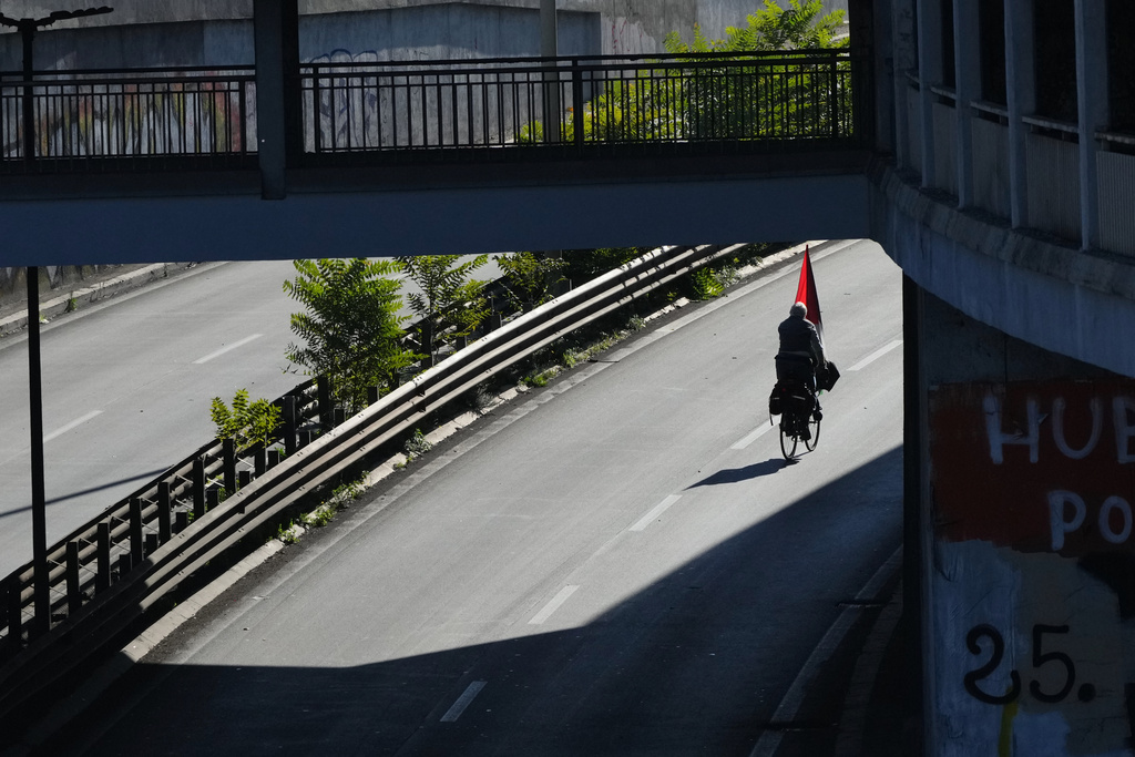A pro-Palestinian demonstrator rides his bicycle along the Rome's ring road as he gathers for a national general strike called by different unions to protest against the situation in Gaza two days after Israeli forces intercepted a Gaza-bound aid flotilla in the Mediterranean Sea, in Rome, Friday, Oct. 3, 2025. (AP Photo/Alessandra Tarantino)