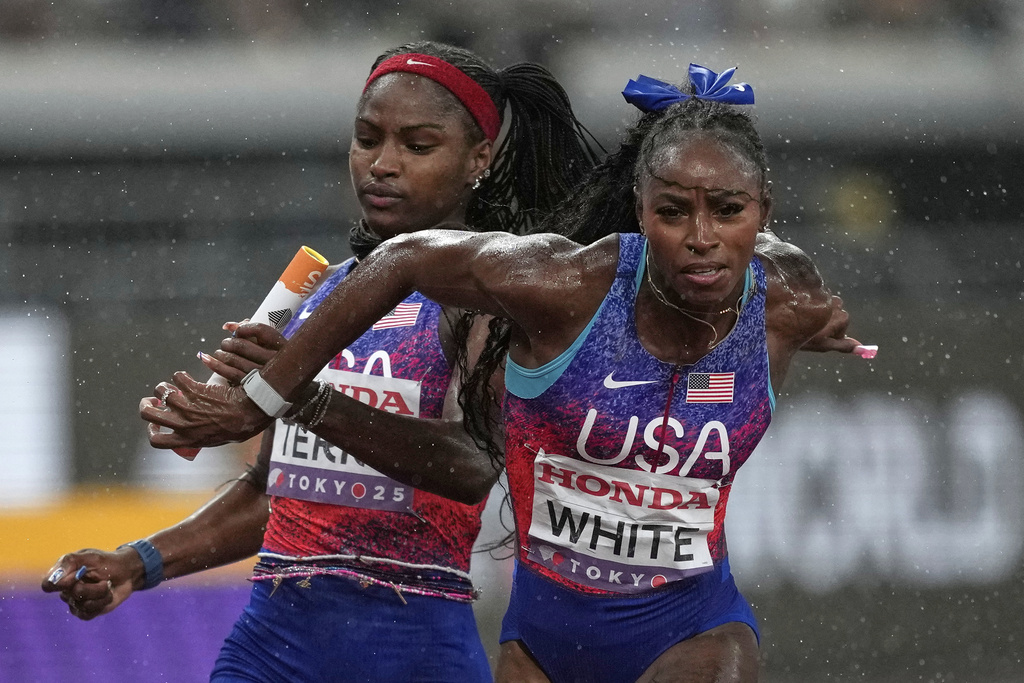 United States' Twanisha Terry passes the baton to Kayla White in the women's 4 X 100 meters relay final at the World Athletics Championships in Tokyo, Sunday, Sept. 21, 2025 (AP Photo/Louise Delmotte)