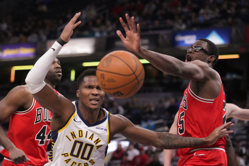 Indiana Pacers guard Bennedict Mathurin (00) and Chicago Bulls forward Jalen Smith (25) reach for a loose ball during the first half of an NBA basketball game in Indianapolis, Wednesday, Jan. 28, 2026. (AP Photo/Michael Conroy)