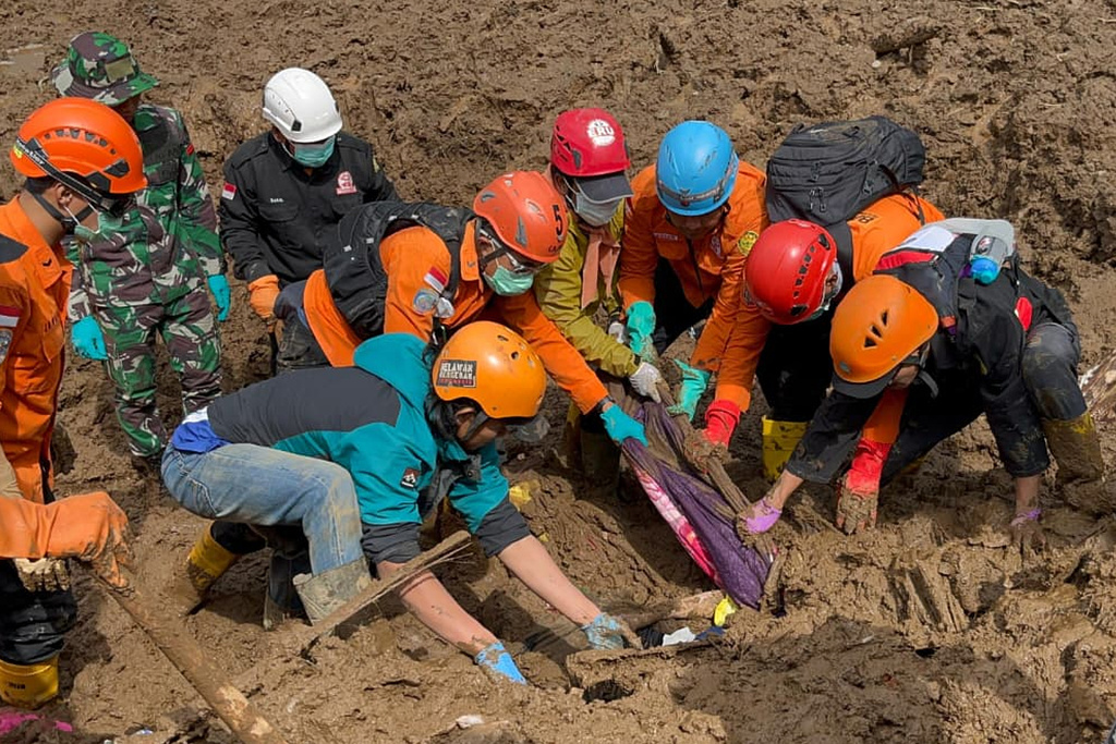 In this photo released by the Indonesian National Search and Rescue Agency (BASARNAS), rescuers search for victims in Pasir Langu village after a landslide, in West Bandung district of West Java province, Indonesia, Sunday, Jan. 25, 2026. (BASARNAS via AP)