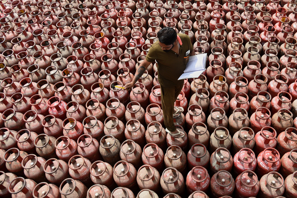 A worker inspects liquefied petroleum gas cylinders, arranged for customer delivery at a distribution centre on the outskirts of Amritsar, India, Friday, March 13, 2026. (AP Photo/Prabhjot Gill)