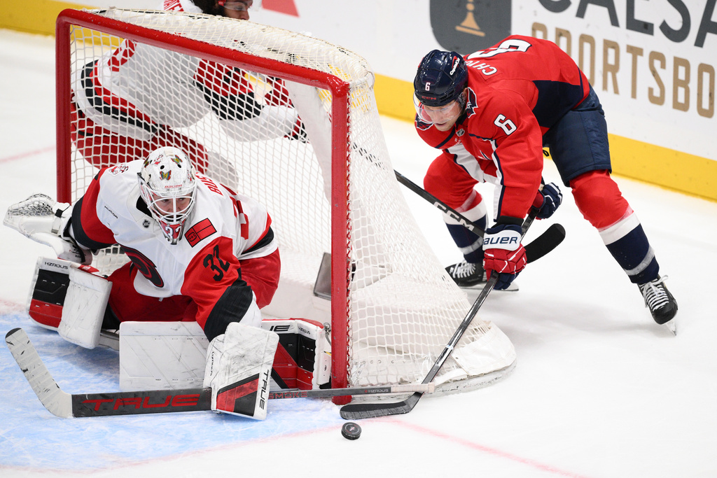 Washington Capitals defenseman Jakob Chychrun (6) tries to get the puck past Carolina Hurricanes goaltender Brandon Bussi (32) during the third period of an NHL hockey game, Thursday, Dec. 11, 2025, in Washington. (AP Photo/Nick Wass)