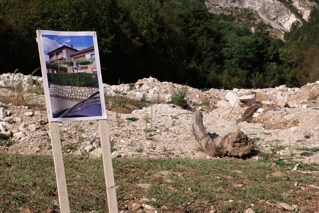 Photographs of houses are placed on the spot where they were built, a year after floods and a landslide swept through the tiny village of Donja Jablanica in southern Bosnia, killing 19 people, Saturday, Oct. 4, 2025. (AP Photo/Eldar Emric)