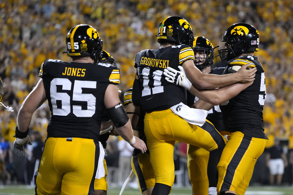 Iowa quarterback Mark Gronowski (11) celebrates with teammates after a touchdown run during the first half of an NCAA college football game against Massachusetts, Saturday, Sept. 13, 2025, in Iowa City, Iowa. (AP Photo/Charlie Neibergall)