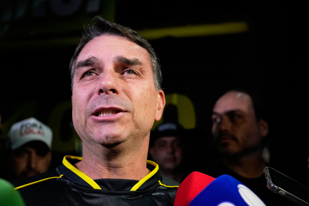Flavio Bolsonaro, son of ex-President Jair Bolsonaro, speaks during a vigil outside the former president's residence in Brasília, Brazil, Saturday, Nov. 22, 2025, after his father's arrest earlier in the day, carried out days before he was set to start serving his 27-year sentence for leading a coup attempt. (AP Photo/Eraldo Peres)