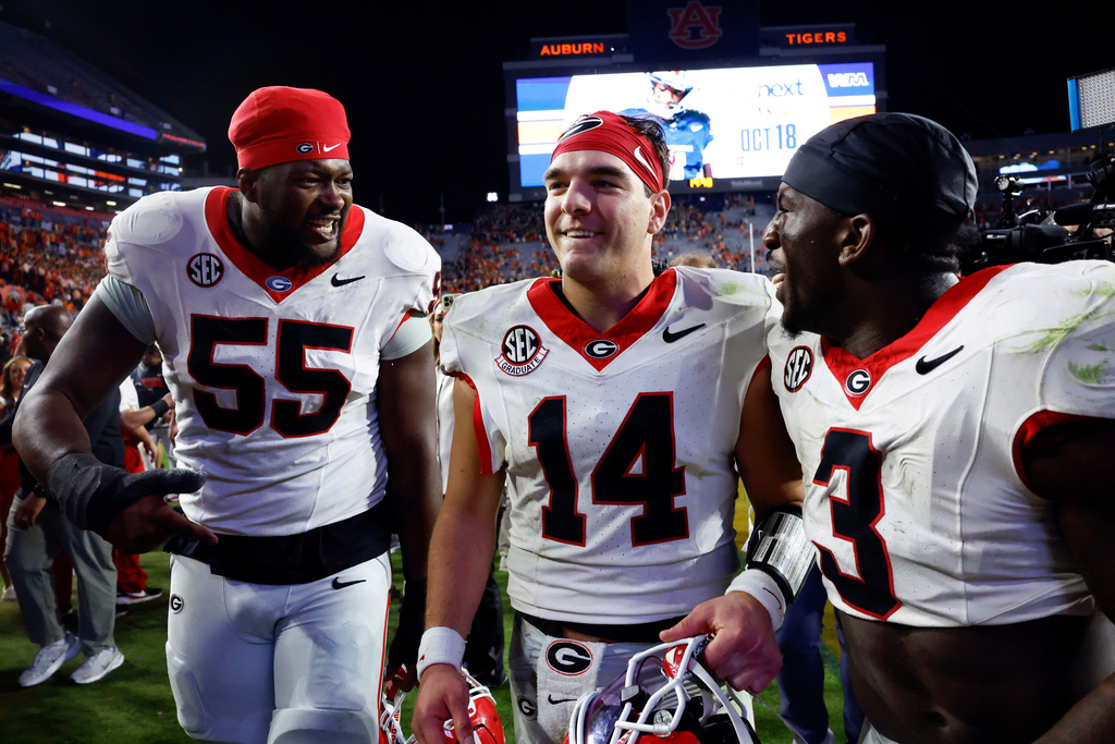 Georgia quarterback Gunner Stockton (14) celebrates with teammates after a win over Auburn in an NCAA college football game, Saturday, Oct. 11, 2025, in Auburn, Ala. (AP Photo/Butch Dill)