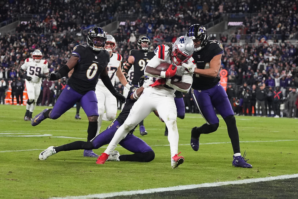 New England Patriots running back Rhamondre Stevenson, middle, runs toward the end zone to score against the Baltimore Ravens during the second half of an NFL football game, Sunday, Dec. 21, 2025, in Baltimore. (AP Photo/Stephanie Scarbrough)