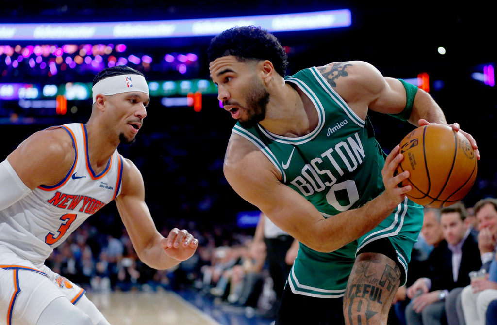 New York Knicks guard Josh Hart, left, defends against Boston Celtics forward Jayson Tatum during the second half of an NBA basketball game Thursday, April 9, 2026, in New York. (AP Photo/John Munson)