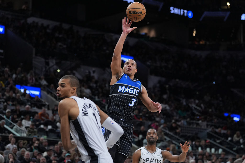 Orlando Magic guard Desmond Bane (3) shoots over San Antonio Spurs forward Victor Wembanyama (1) during the first half of an NBA basketball game in San Antonio, Sunday, Feb. 1, 2026. (AP Photo/Eric Gay)