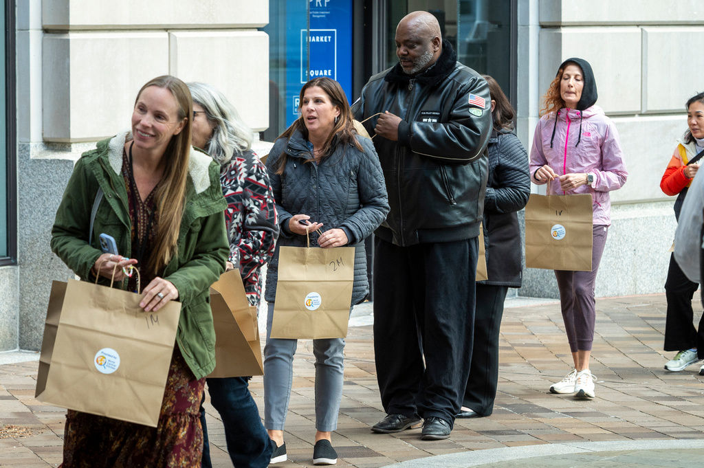 Federal workers stand in line to pickup meals from the World Central Kitchen, Wednesday, Nov. 12, 2025, in Washington. (AP Photo/Cliff Owen)