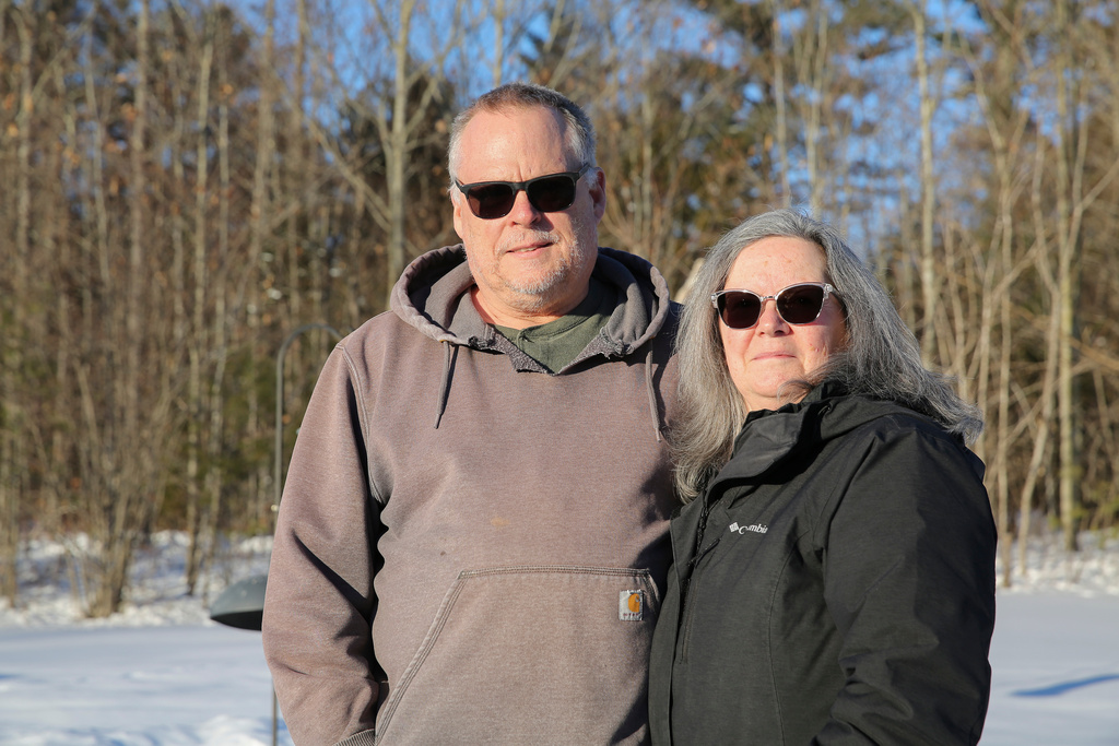 Dan, left, and Lanita Canavan stand outside their home, Monday, Feb. 2, 2026, in rural Lewis, N.Y., where they and fellow residents fear a proposed howitzer testing range in their Adirondacks town would shatter the rural area's tranquility and scare wildlife. (AP Photo/Michael Hill)