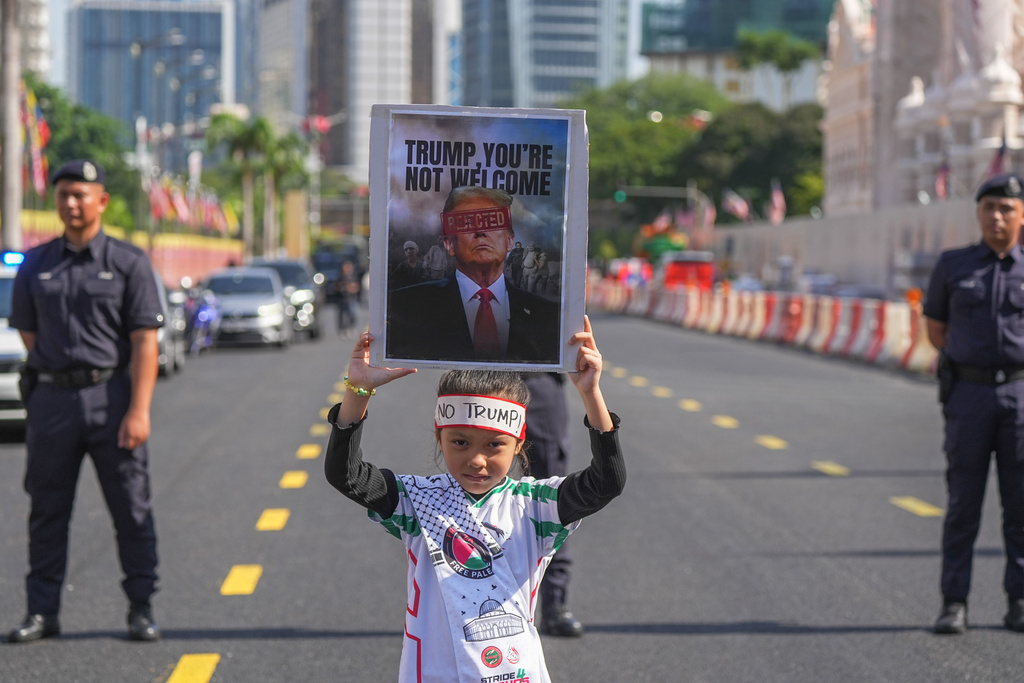 A child holds a sign during a demonstration against U.S. President Donald Trump's attendance at the Association of Southeast Asian Nations (ASEAN) Summit in Kuala Lumpur, Malaysia, on Sunday, Oct. 26, 2025. (AP Photo/Azneal Ishak)