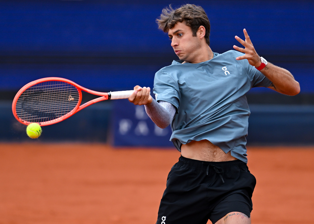 Italy's Flavio Cobolli in action against Ben Shelton of the US during the men's singles final match at the ATP Tour in Munich, Germany, Sunday April 19, 2026. (Sven Hoppe/dpa via AP)
